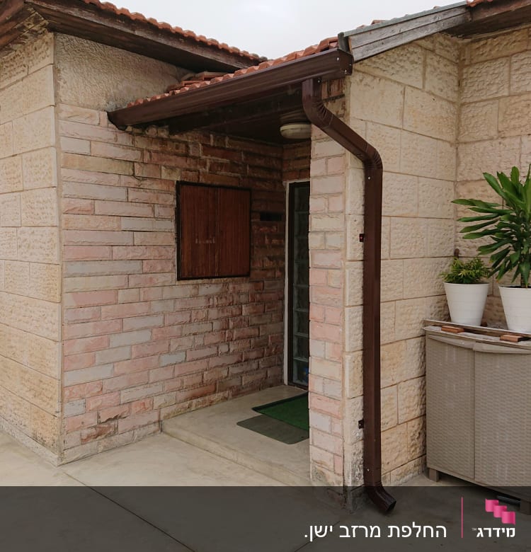 מרזב חום מחובר לגג רעפים אדום